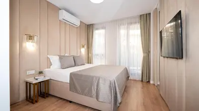 a hotel room with a bed and a television at Harmony Suites Grand Resort in Sunny Beach