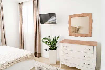 a bedroom with a white dresser and a mirror at KApartments in Varna City