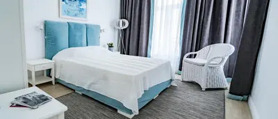 a hotel room with a bed and a chair at KApartments in Varna City