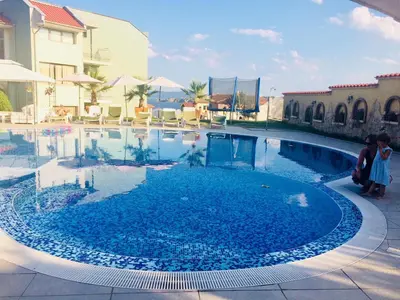 a swimming pool with blue water in a resort at Gardenia Suites in Sozopol