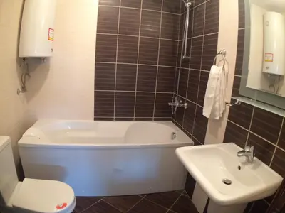 a bathroom with a tub and a toilet and a sink at Chateau Del Marina Penthouses in Nesebar
