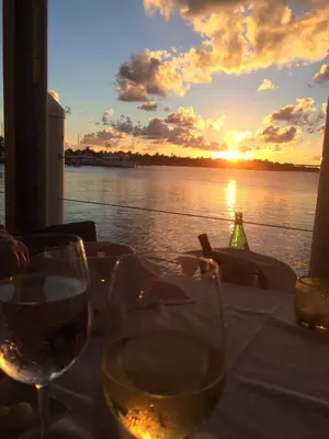 a table with wine glasses in front of a sunset at Chateau Del Marina Penthouses in Nesebar
