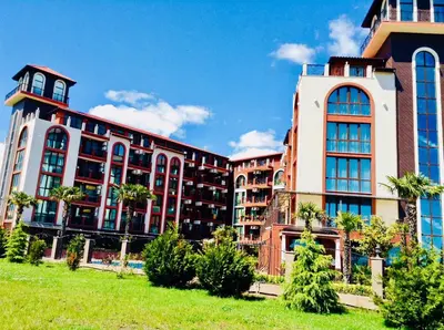 a large building with palm trees in front of it at Chateau Del Marina Penthouses in Nesebar