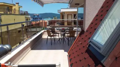 a balcony with a table and chairs on a building at Guest House Donchevi in Primorsko