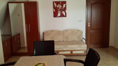 a living room with a couch and a table and chairs at Guest House Donchevi in Primorsko