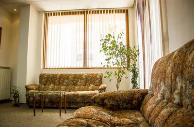 a living room with a couch and a chair and a window at Family Hotel Saint Iliya in Burgas City