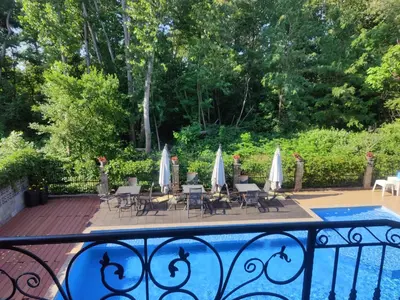 a patio with chairs and umbrellas and a pool at Park and pool Studio Apostolovi in Nesebar