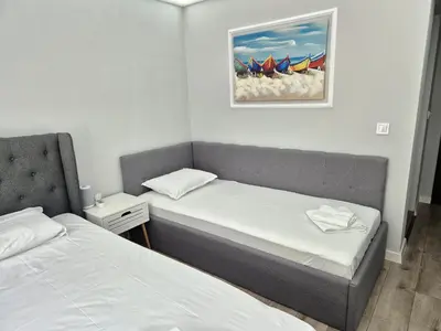 a room with two beds and a picture on the wall at Park and pool Studio Apostolovi in Nesebar