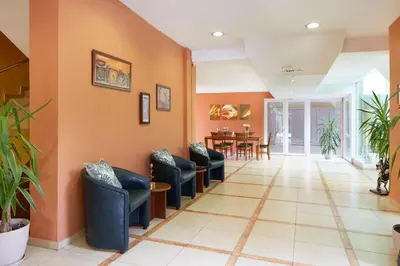 a waiting room with blue chairs and a table at Apart Hotel Vechna R in Sunny Beach