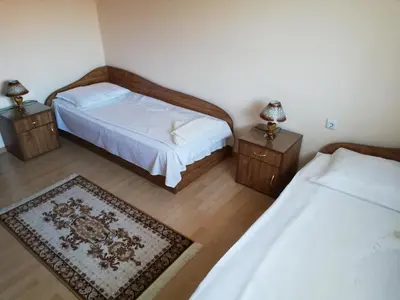 a bedroom with two beds and two night stands at апартамент Росен in Nesebar