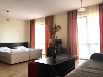 a hotel room with a bed and a coffee table at Апартхотел Созополски перли in Sozopol