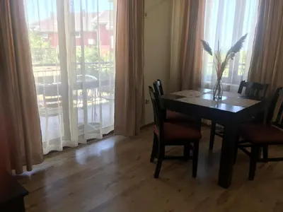 a dining room with a table and chairs and a window at Апартхотел Созополски перли in Sozopol