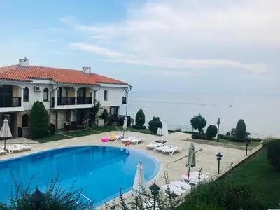 a villa with a swimming pool and the ocean at PS Apartment / SunCoast Resort in Sveti Vlas