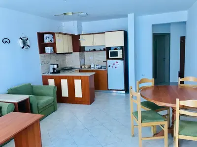 a kitchen and living room with a table and a kitchen and a dining room at PS Apartment / SunCoast Resort in Sveti Vlas