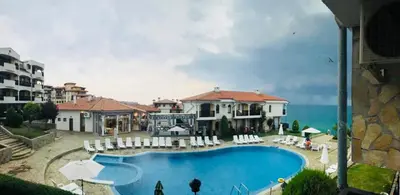 a house with a swimming pool next to the ocean at PS Apartment / SunCoast Resort in Sveti Vlas