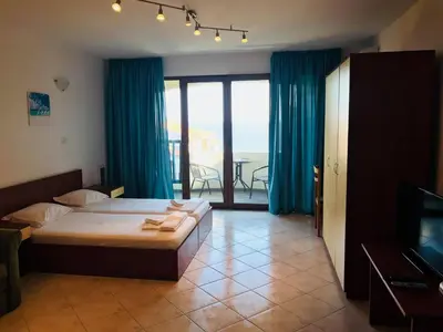 a bedroom with a bed and a view of the ocean at PS Apartment / SunCoast Resort in Sveti Vlas