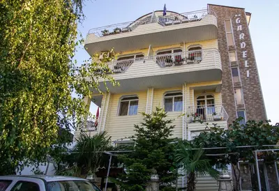 a yellow building with balconies on the side of it at Guest House Gardeli in Tsarevo