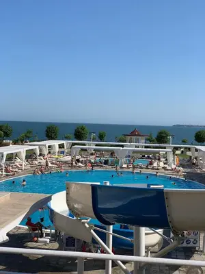 a large swimming pool with people in the water at Private Apartment 49 in Prestige Fort Beach Hotel in Sveti Vlas
