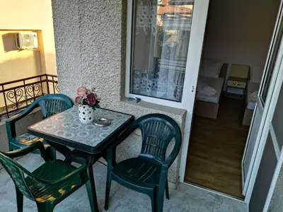 a table and two chairs and a table and a balcony at Къща за гости Слънчевият ъгъл - The sunny corner in Sozopol