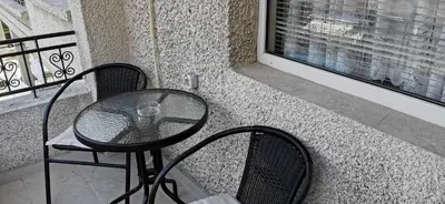 a glass table and two chairs on a balcony at Къща за гости Слънчевият ъгъл - The sunny corner in Sozopol