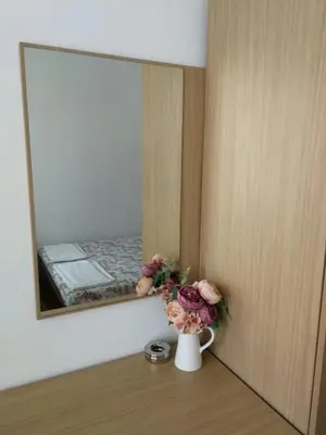 a vase with flowers on a table in front of a mirror at Къща за гости Слънчевият ъгъл - The sunny corner in Sozopol