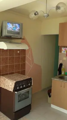 a kitchen with a stove and a tv on the wall at Апартамент Флора - гр.Приморско ММЦ in Primorsko
