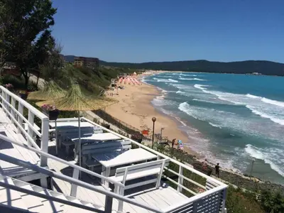 a view of a beach with umbrellas and the ocean at Ashram Hotel in Primorsko