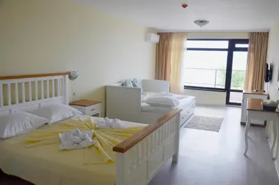 a bedroom with two beds and a large window at Ashram Hotel in Primorsko