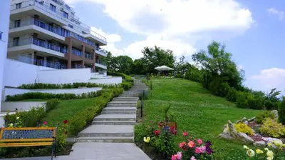 a garden with stairs and flowers next to a building at Апартаменти Бяла Клиф на плажа - Apartments Byala Cliff First Line in Byala