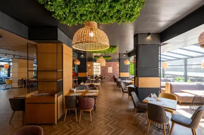 a restaurant with tables and chairs in a room at Avenue Hotel Deluxe in Burgas City