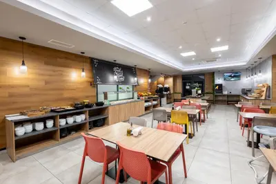 a restaurant with wooden walls and tables and chairs at Avenue Hotel Deluxe in Burgas City