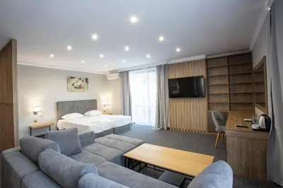 a hotel room with a bed and a couch at Avenue Hotel Deluxe in Burgas City