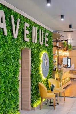 a green wall with a sign on it in a store at Avenue Hotel Deluxe in Burgas City