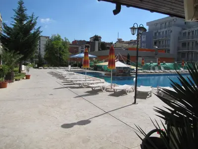 a row of chairs and umbrellas next to a pool at SB Rentals Apartments in Royal Dreams Complex in Sunny Beach