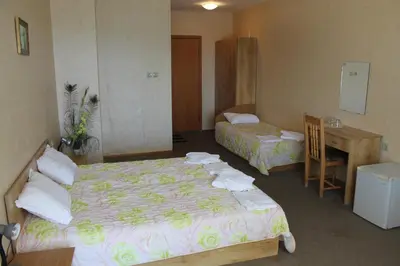a hotel room with two beds and a desk at The White House in Bliznatsi