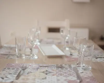 a wooden table with wine glasses and utensils on it at Aleksapart in Burgas City