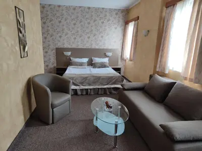 a living room with a bed and a couch at Семеен Хотел 