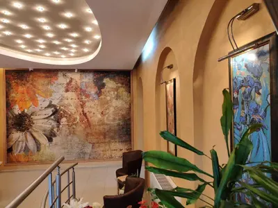 a lobby with a large painting on the wall at Семеен Хотел 