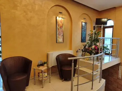 a waiting room with two chairs and a table at Семеен Хотел 