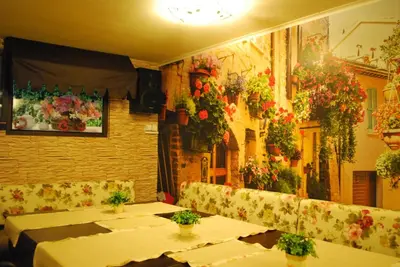 a restaurant with tables and flowers on the wall at Семеен Хотел 