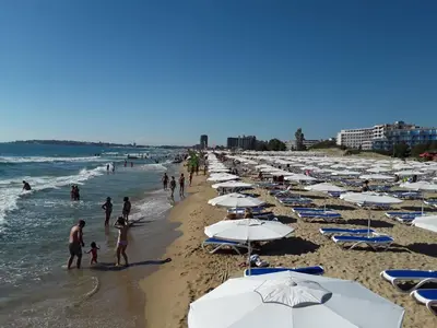 a group of people on a beach with umbrellas at CHATEAU DEL MAR C31a Studio Sunny Beach in Sunny Beach