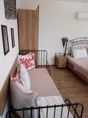 a bedroom with two beds and a wooden floor at Family Hotel Bellehouse in Chernomorets