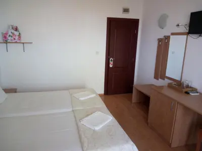 a bedroom with a bed and a vanity and a mirror at Family Hotel Bellehouse in Chernomorets