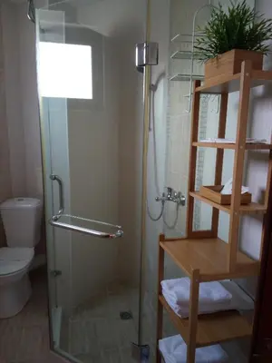 a bathroom with a shower and a toilet at Family Hotel Bellehouse in Chernomorets