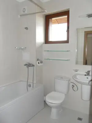 a white bathroom with a toilet and a sink at HillTop Villa in Burgas City