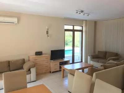 a living room with a couch and a tv and a table at HillTop Villa in Burgas City