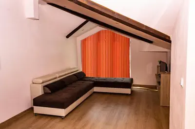 a living room with a couch and a red curtain at New Star Residence in Burgas City