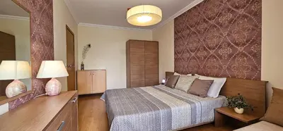 a bedroom with a bed and two lamps and a couch at Excelsior Holiday Apartments Sunny Beach in Sunny Beach