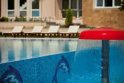 a swimming pool with chairs next to a swimming pool at Atia Resot in Chernomorets