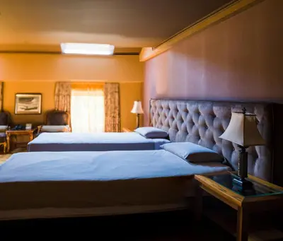 a hotel room with two beds and a table with a lamp at Ventura Boutique Hotel in Varna City